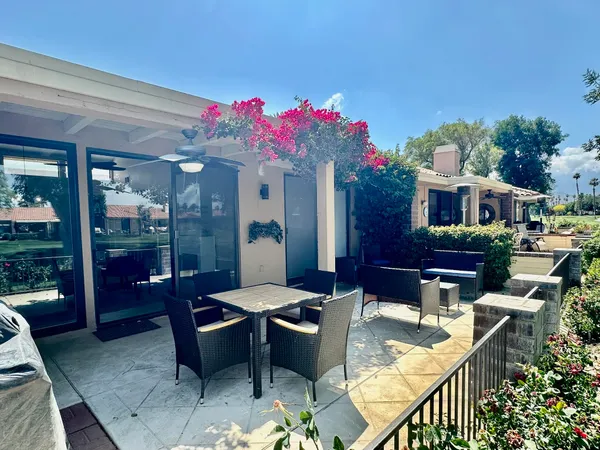 a view of a patio with couches table and chairs and potted plants