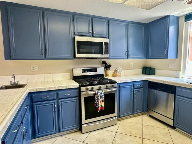 a kitchen with granite countertop a stove top oven microwave and cabinets