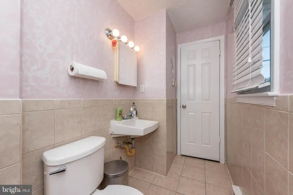 a bathroom with a toilet a sink and mirror