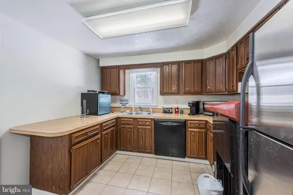 a kitchen with a sink a stove top oven and refrigerator