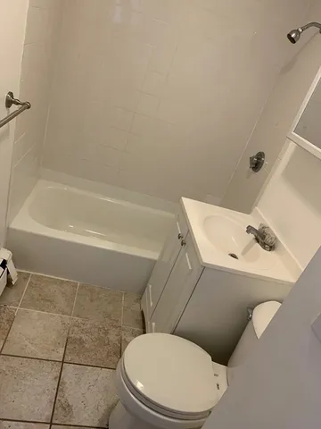 a white toilet and tub sitting next to a bathroom sink