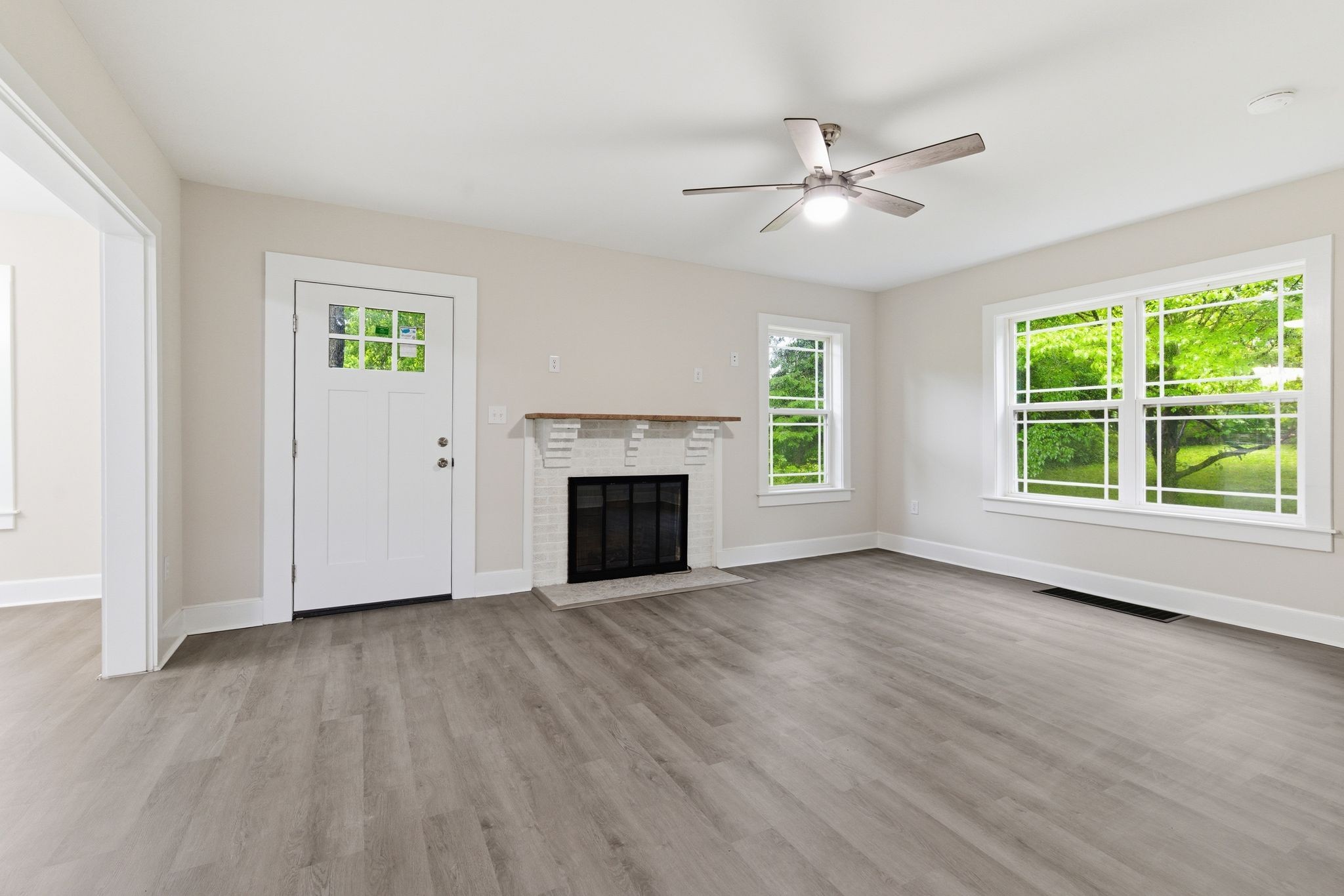 305 South Irwin Street Manchester, TN 37355 - Photo 7 of 40 an empty room with wooden floor a ceiling fan and windows