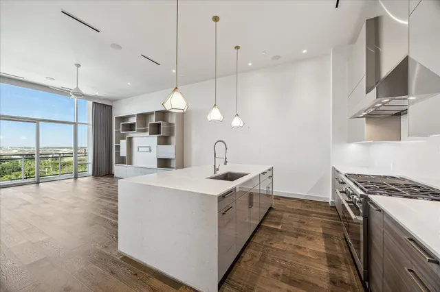 a open kitchen with stainless steel appliances granite countertop a sink a stove and a wooden floors