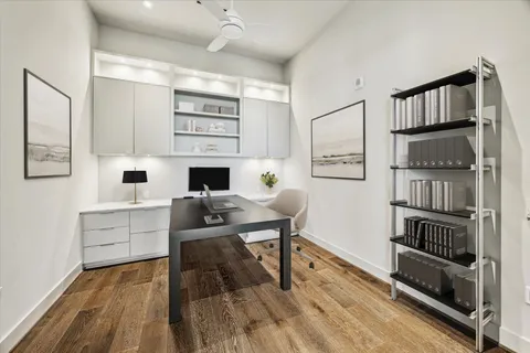 a living room with stainless steel appliances furniture a rug and a book shelf