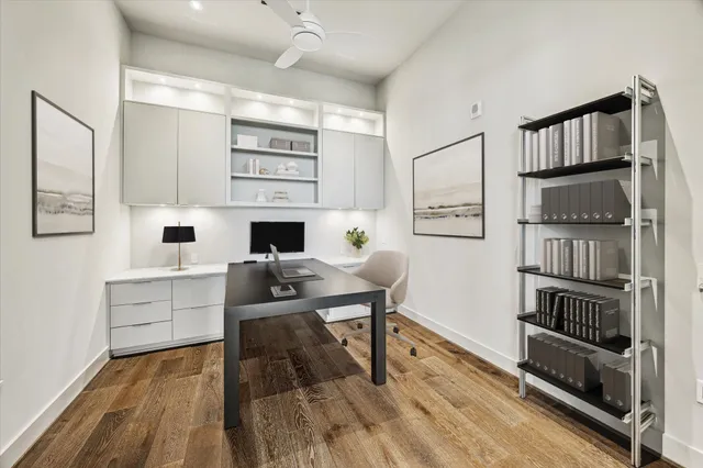 a living room with stainless steel appliances furniture a rug and a book shelf