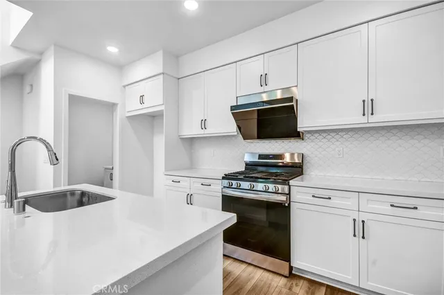 a kitchen with white cabinets and stainless steel appliances