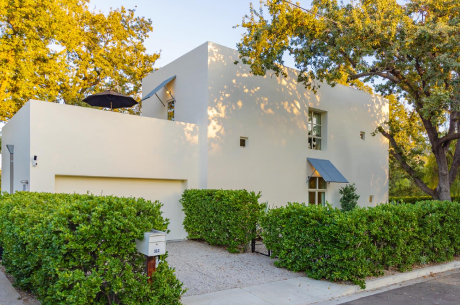 a view of a house with a tree in front of it