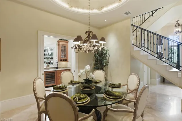 a dining room with furniture a chandelier and wooden floor