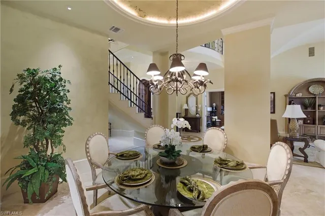a dining room with furniture a chandelier and wooden floor