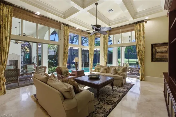 a living room with furniture ceiling fan and a large window
