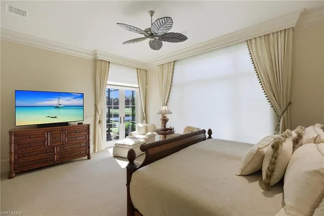a bedroom with a large bed and a flat tv screen