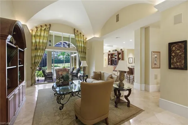 a living room with furniture a large window and glass door