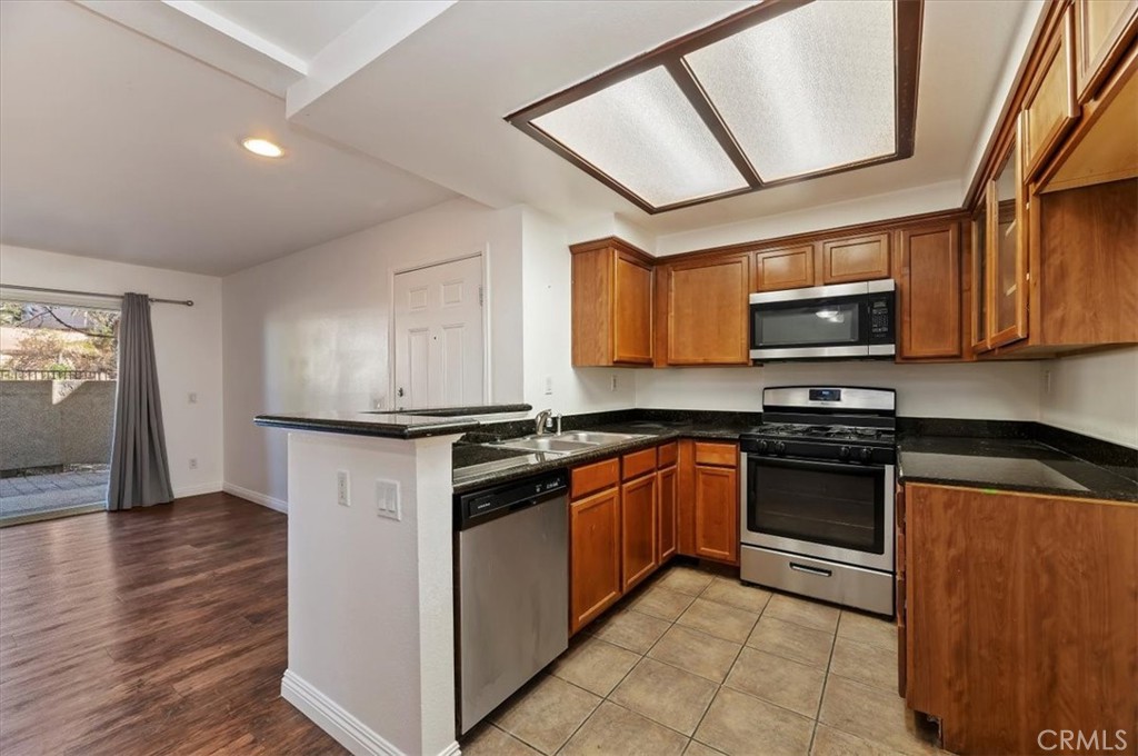200 East Alessandro Boulevard, Unit 79 Riverside, CA 92508 - Photo 12 of 30 a kitchen with stainless steel appliances granite countertop a stove a sink and a microwave