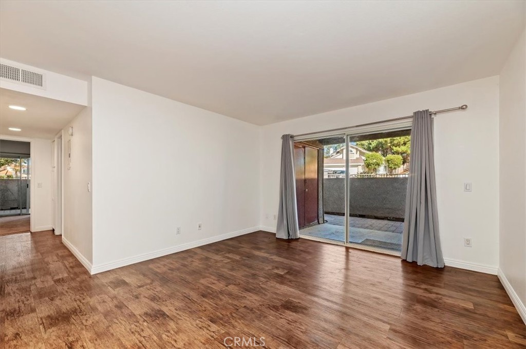 200 East Alessandro Boulevard, Unit 79 Riverside, CA 92508 - Photo 5 of 30 an empty room with wooden floor and windows