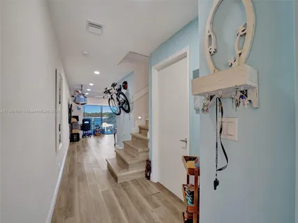 a kitchen with stainless steel appliances granite countertop a refrigerator a stove and a dining table with wooden floor