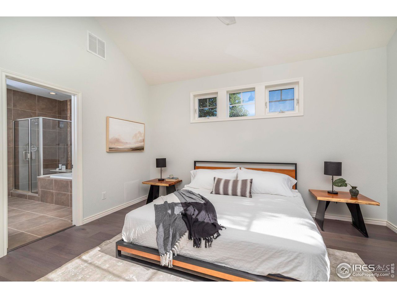 5065 3rd Street Boulder, CO 80304 - Photo 13 of 40 a bedroom with a bed a mirror and wooden floor