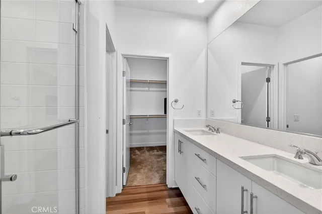 a spacious bathroom with a double vanity sink a mirror and shower