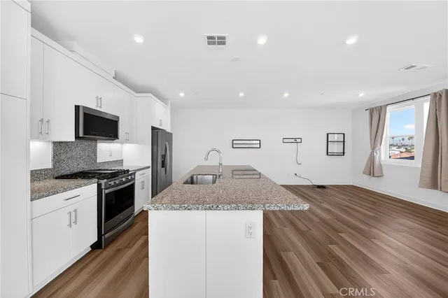 a kitchen with a stove and a wooden floor
