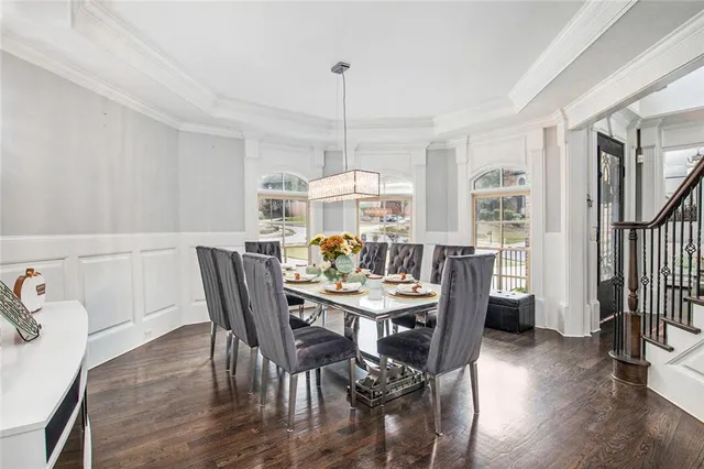 a kitchen with stainless steel appliances a stove a sink a oven a dining table and chairs