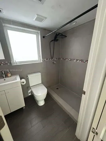 a bathroom with a toilet a sink and a shower