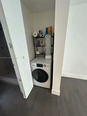 a room with a wooden floor and washing machine