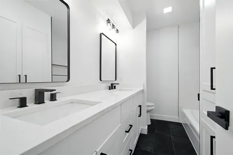 a bathroom with a double vanity sink and mirror