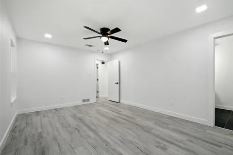 wooden floor in an empty room with a fan
