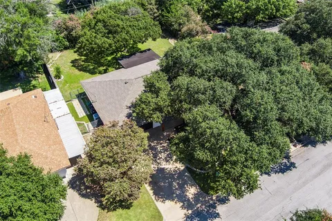 an aerial view of a house with a yard and greenery