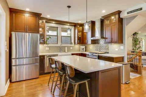 a kitchen with stainless steel appliances granite countertop a refrigerator a sink and a stove