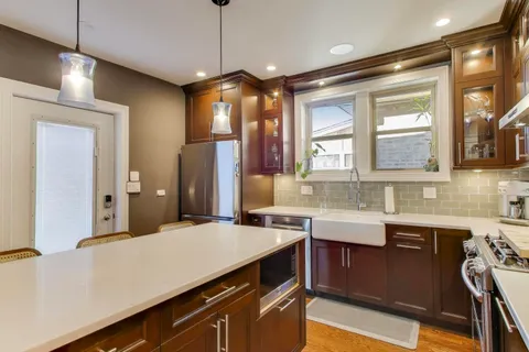 a kitchen with a sink a counter space appliances and cabinets