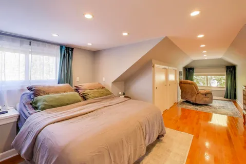 a bedroom with a large bed and wooden floors