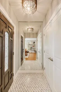 a view of a hallway with wooden floor and a chandelier