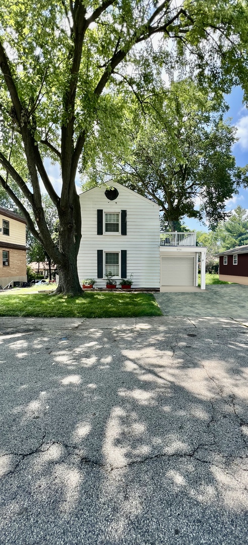 564 Mann Place Elgin, IL 60120 - Photo 3 of 28 a white house that has a tree in front of it