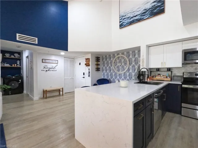 a kitchen with stainless steel appliances a refrigerator sink stove and microwave