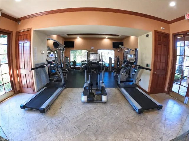 a living room with furniture gym equipment and a large window