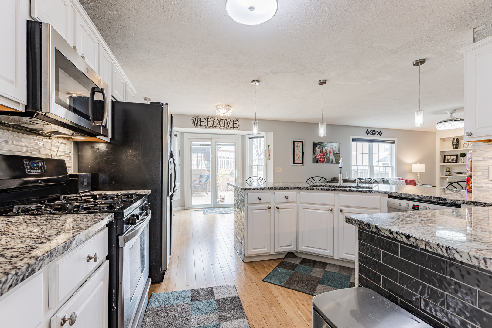 4401 Copper Ridge Road Champaign, IL 61822 - Photo 23 of 49 a kitchen with stainless steel appliances granite countertop a stove top oven a sink dishwasher a dining table and chairs with wooden floor
