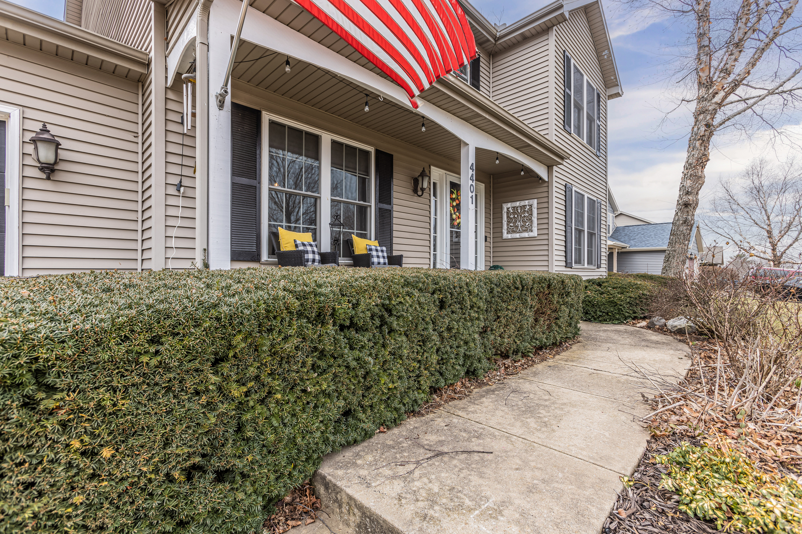 4401 Copper Ridge Road Champaign, IL 61822 - Photo 7 of 49 a view of a house with a small yard and floor to ceiling window and potted plants