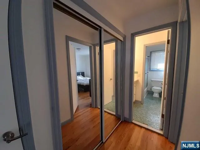 a view of a hallway with wooden floor and staircase
