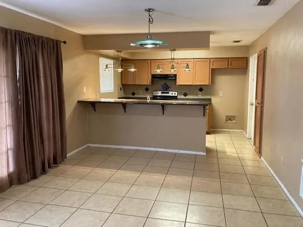 a view of kitchen with stainless steel appliances granite countertop a refrigerator and a sink