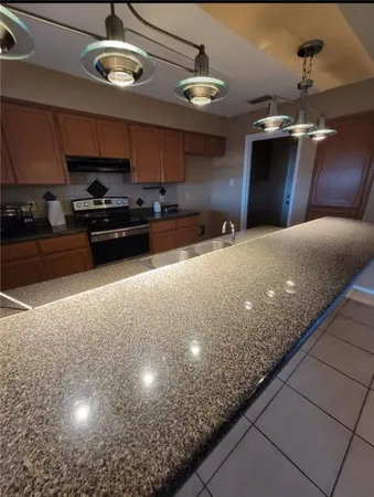 a kitchen with stainless steel appliances granite countertop a sink a stove and a cabinets