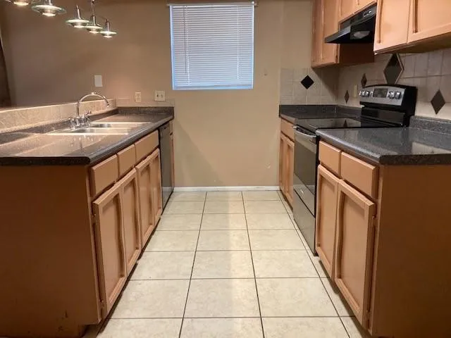 a kitchen with a sink stove and cabinets