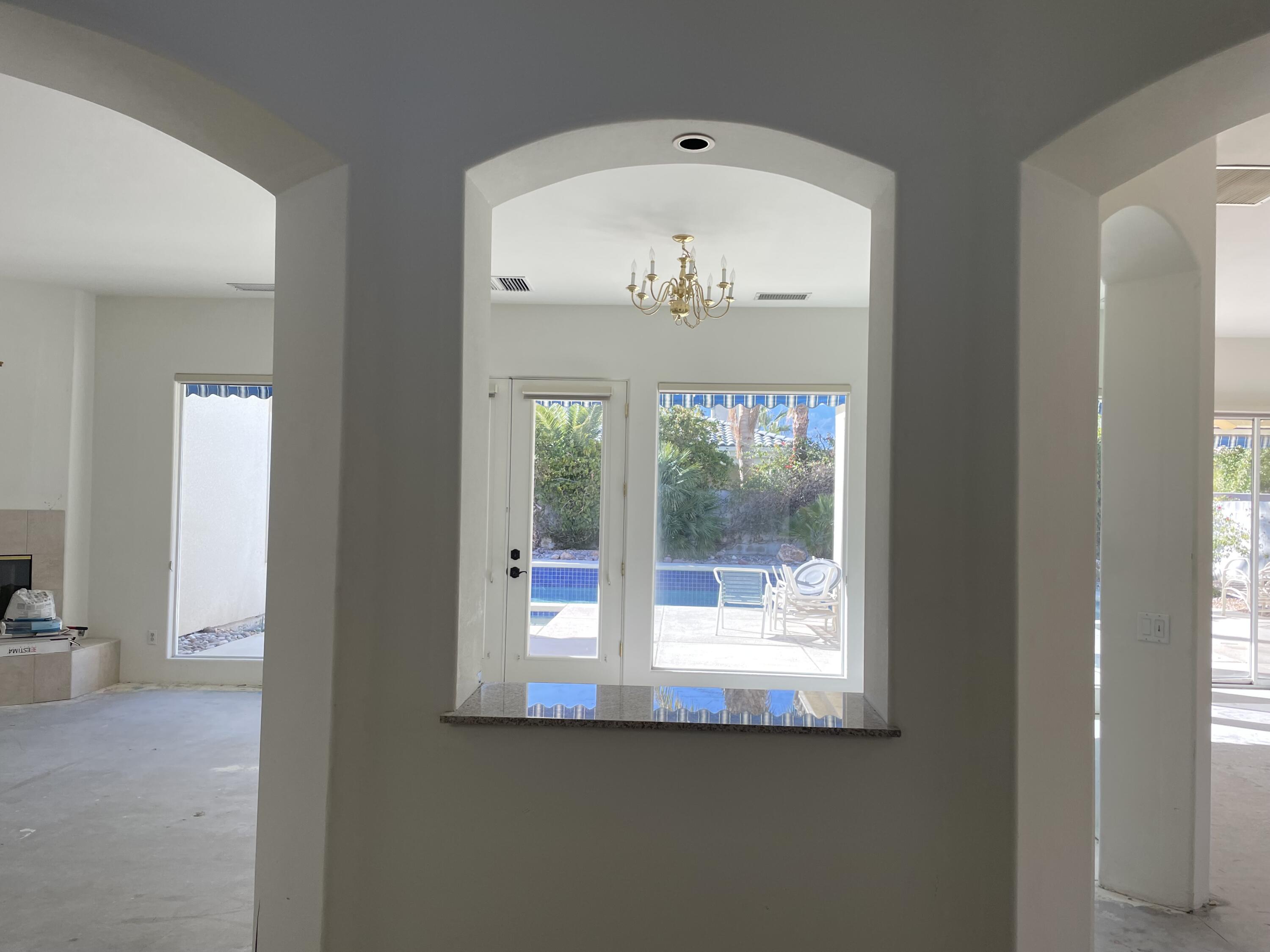 3 King Edward Court Rancho Mirage, CA 92270 - Photo 2 of 20 an empty room with wooden floor and windows