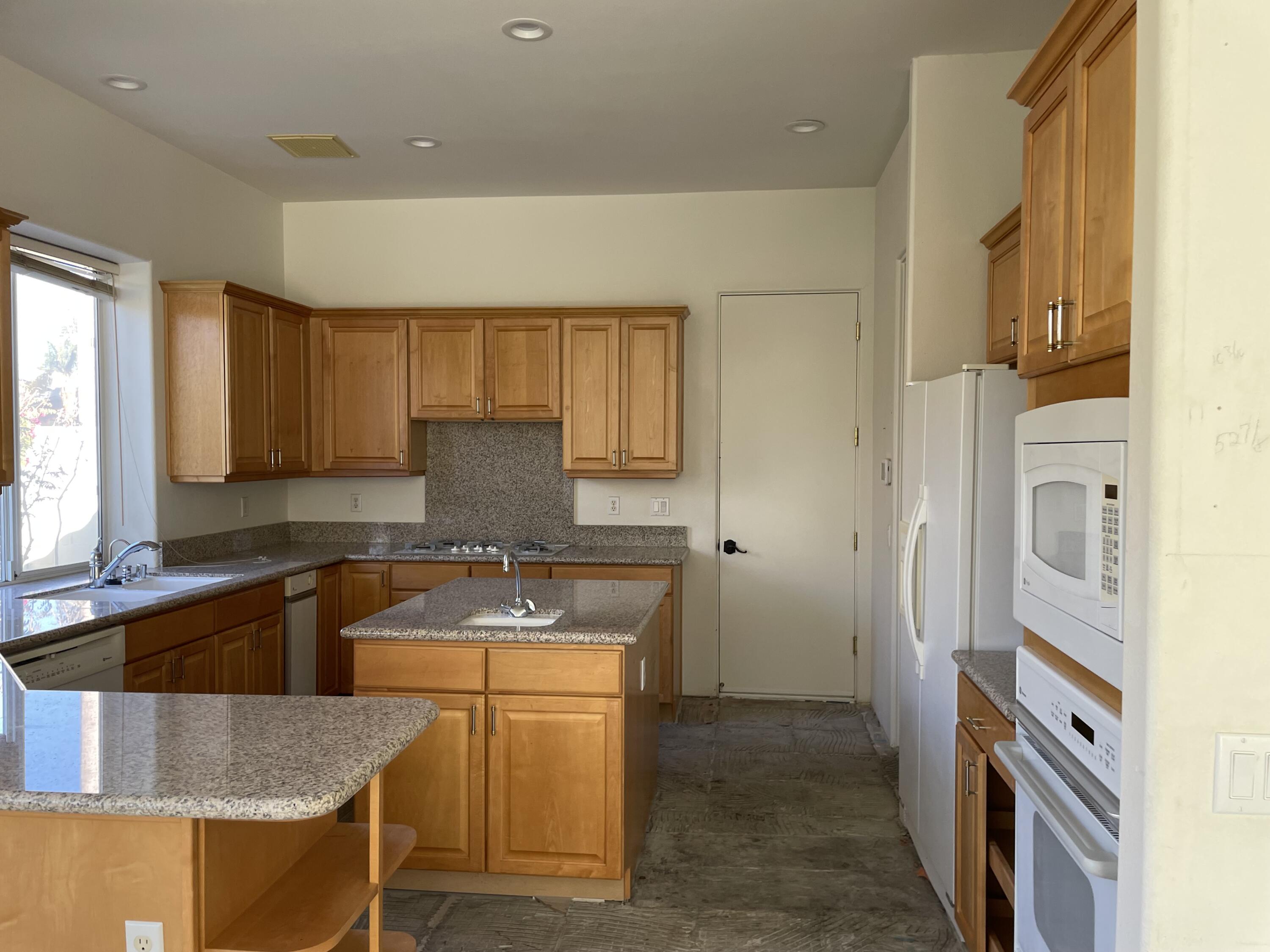 3 King Edward Court Rancho Mirage, CA 92270 - Photo 6 of 20 a kitchen with granite countertop a sink a stove and refrigerator