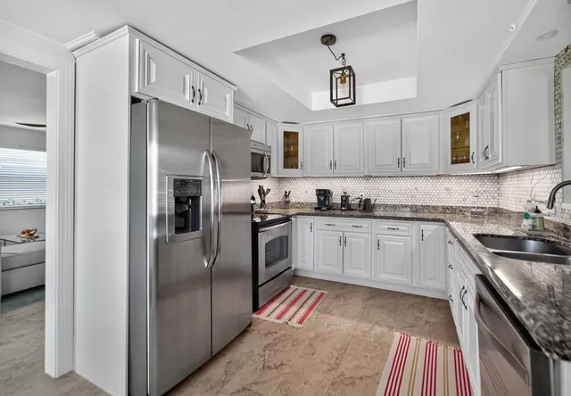 a kitchen with stainless steel appliances granite countertop a refrigerator and a sink