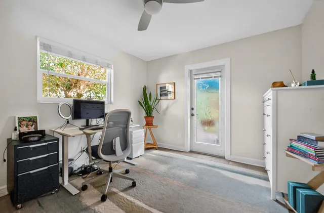 a view of a workspace with furniture and a window