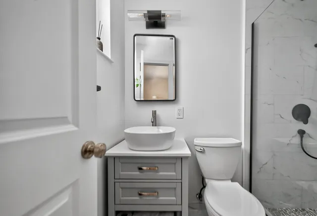 a bathroom with a toilet a sink and mirror