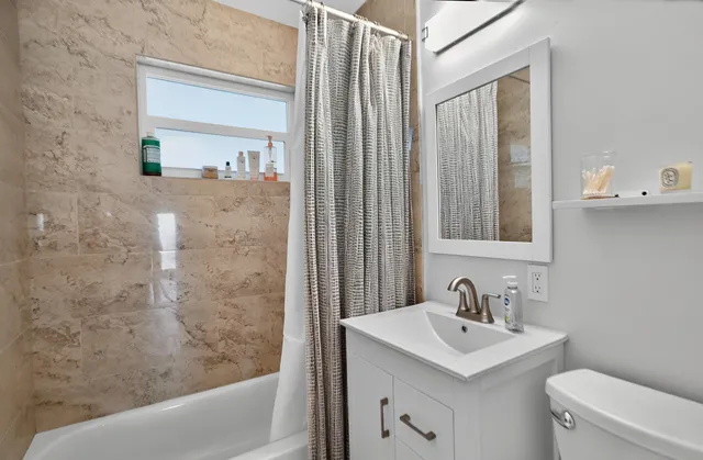 a bathroom with a sink a toilet and shower