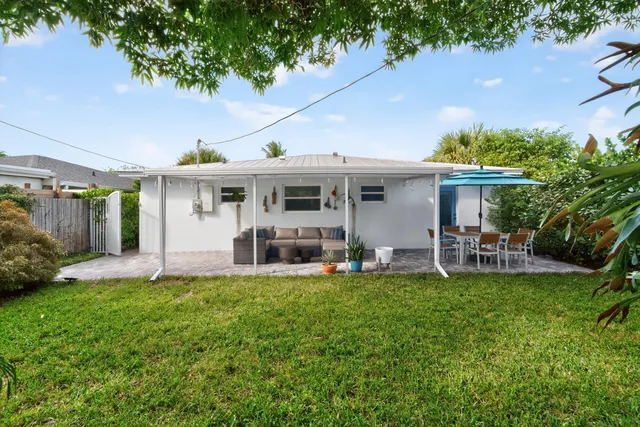 a view of a house with a yard and sitting area