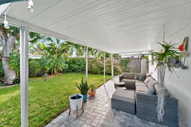 a living room with patio furniture and garden