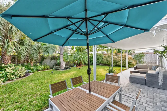 a view of a patio with couches chairs under an umbrella